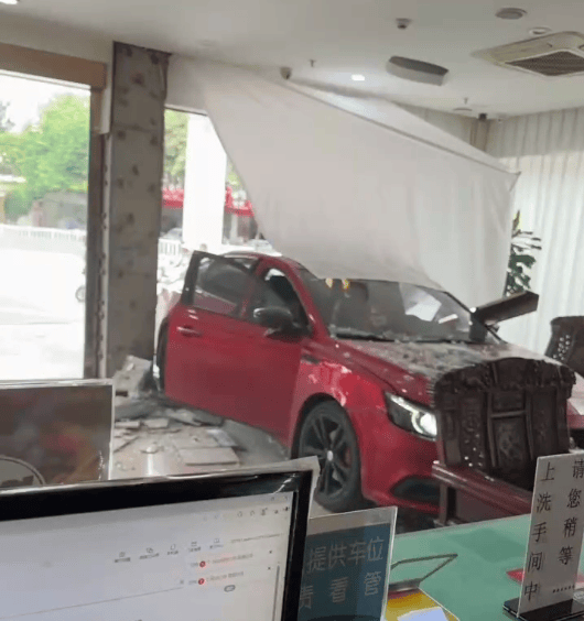 红色小车撞碎酒店玻璃墙冲进大堂, 两男子沙发上跑开躲过一劫;知情人:女司机误把油门当刹车踩