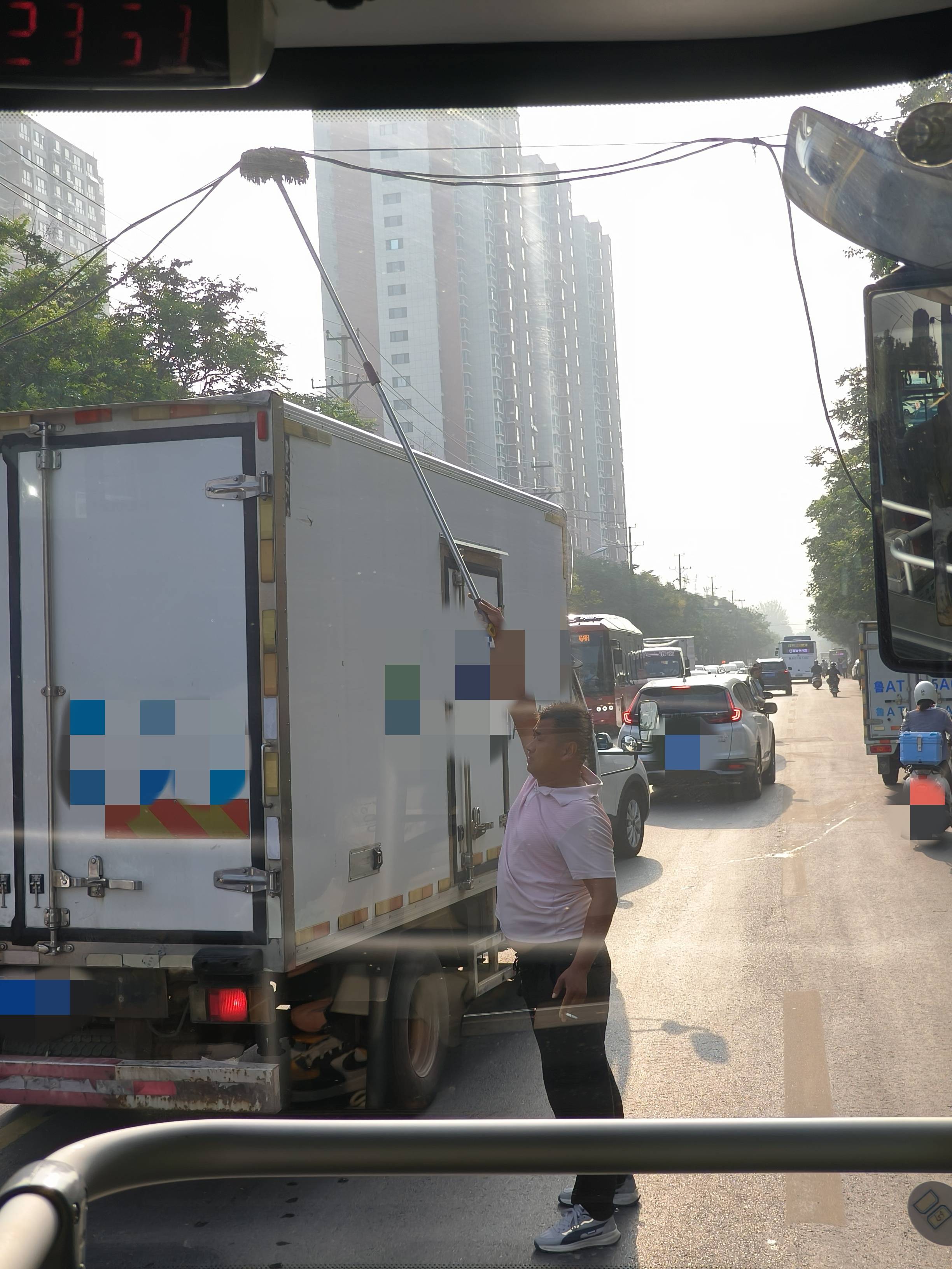 左手夹着烟右手举拖把，济南早高峰时一电线掉落，粉衣大哥化解交通拥堵松弛感拉满！